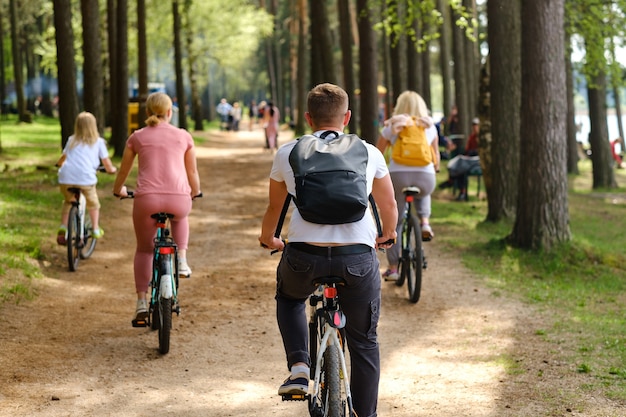 Un gruppo di ciclisti con zaini va in bicicletta su una strada forestale godendosi la natura.