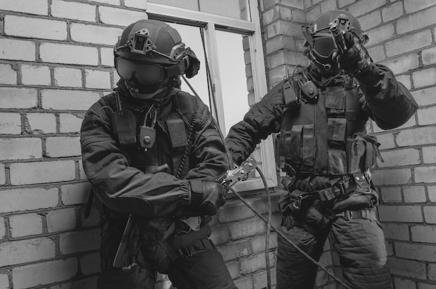 Un gruppo di combattenti delle forze speciali assaltano l'edificio attraverso la finestra. Sessioni di allenamento della squadra SWAT