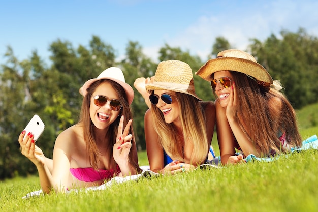 un gruppo di donne in bikini che si fanno selfie all'aperto