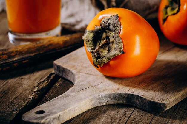 Un gruppo di frutti di cachi arancio maturi Frutti di cachi su un fondo rustico di tavola di legno