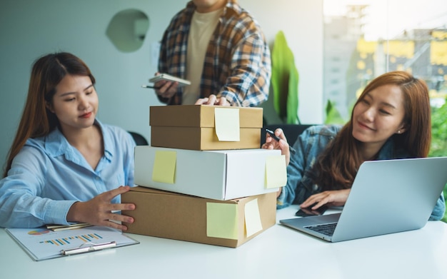 Un gruppo di giovani imprenditori che controllano gli ordini dei clienti per lo shopping online e il concetto di consegna