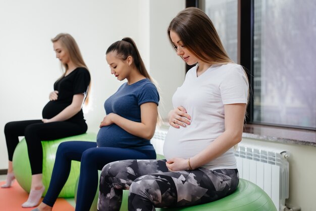 Un gruppo di giovani madri incinte è impegnata in Pilates e sport con la palla in un fitness club. Incinta