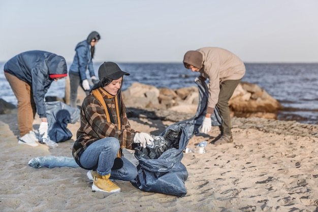 Un gruppo di giovani volontari raccoglie plastica su una spiaggia