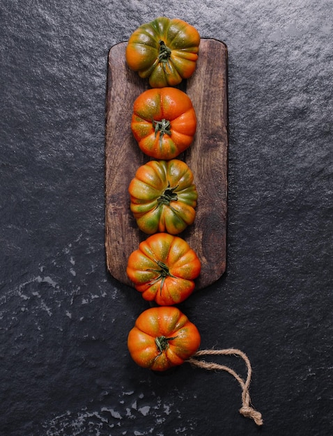 Un gruppo di grandi pomodori Costoluto su un concetto rustico di fondo di legno grigio