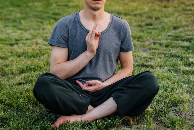 Un gruppo di persone fa yoga nel parco al tramonto