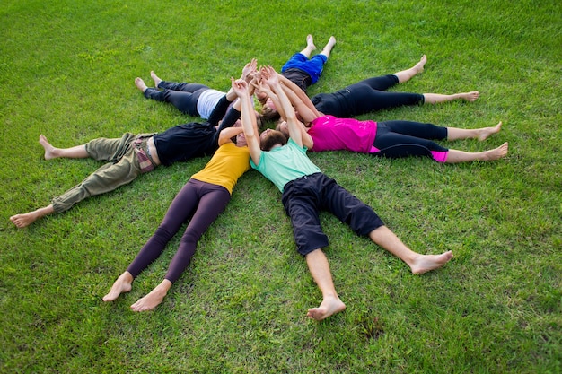 Un gruppo di persone giace su un prato verde in cerchio