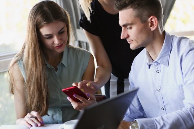 Un gruppo di persone in un caffè guardando l'app per smartphone