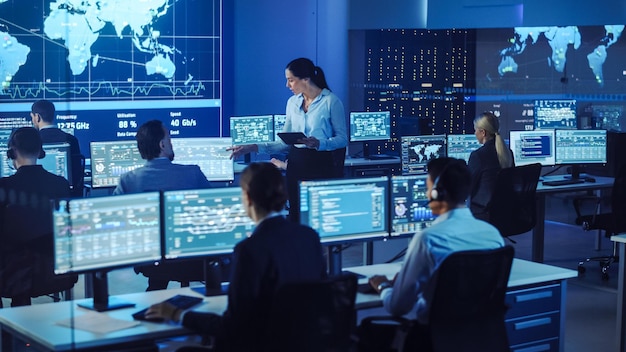 Un gruppo di persone in un laboratorio informatico con un grande schermo che mostra il numero di dati sullo schermo.