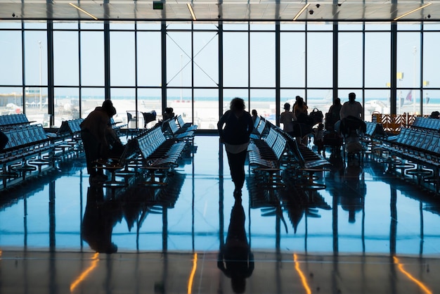 Un gruppo di persone silhouette in aeroporto va alla registrazione con luggagexD