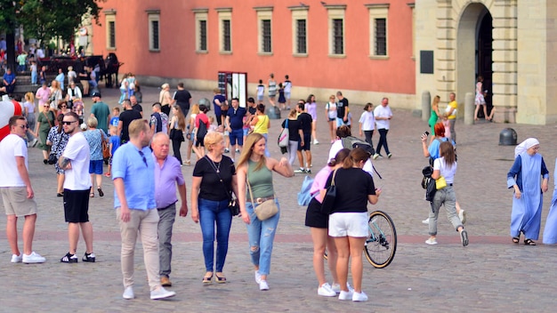 un gruppo di persone sta camminando davanti a un edificio con un edificio rosso sullo sfondo.