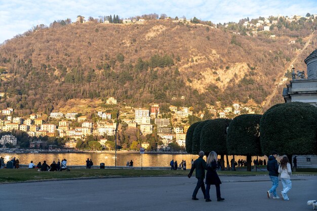 Un gruppo di persone sta camminando in un parco vicino a un lago