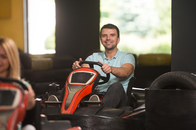 Un gruppo di persone sta guidando un'auto GoKart con velocità in una pista da corsa di un parco giochi Go Kart è un popolare sport automobilistico per il tempo libero