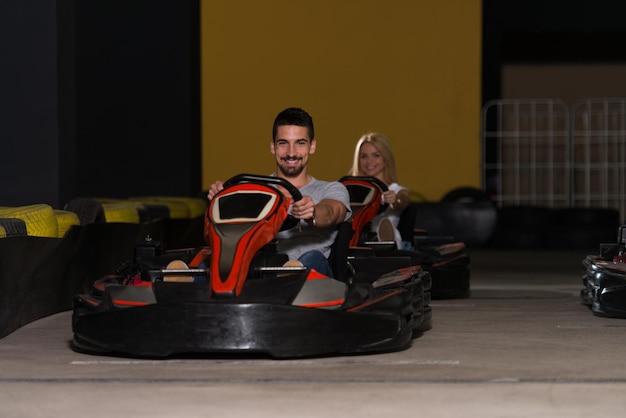 Un gruppo di persone sta guidando un'auto GoKart con velocità in una pista da corsa di un parco giochi Go Kart è un popolare sport automobilistico per il tempo libero