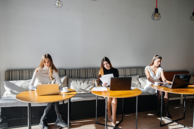 Un gruppo di ragazze si siede in un ufficio e lavora al computer. Comunicazione e formazione online.