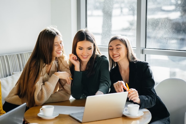 Un gruppo di ragazze si siede in un ufficio e lavora al computer. Comunicazione e formazione online.