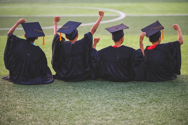 Un gruppo di ragazzi è felice il giorno della laurea a scuola