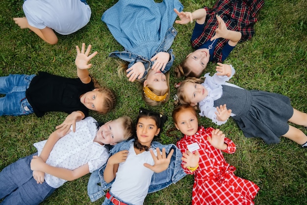 Un gruppo di scolari si sdraia sull'erba in cerchio e si diverte