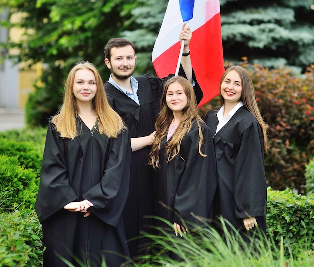 Un gruppo di studenti laureati della Facoltà di Lingue Straniere in toga tiene in mano la bandiera della Francia