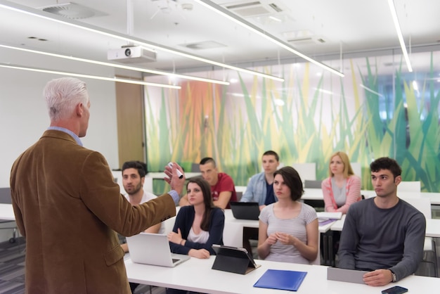 un gruppo di studenti studia con il professore in un'aula scolastica moderna