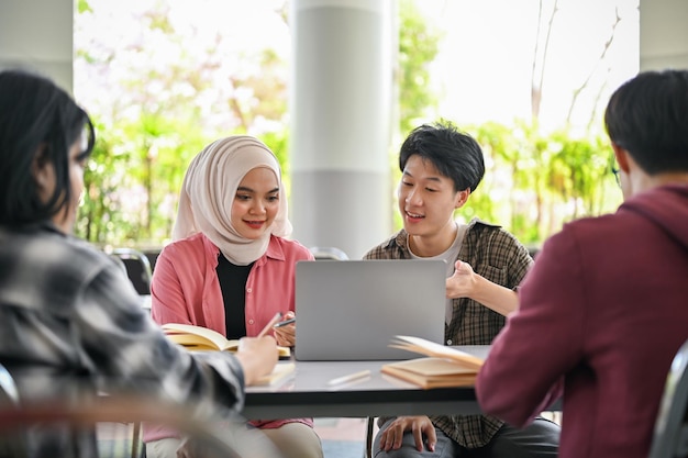 Un gruppo di studenti universitari asiatici eterogenei sta lavorando insieme a un progetto di gruppo scolastico