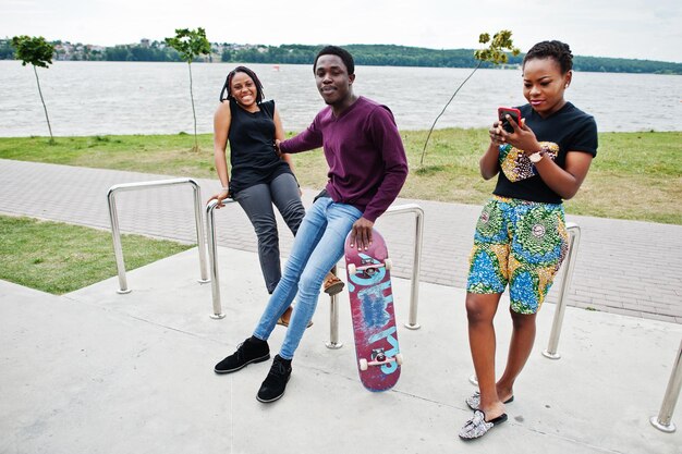 Un gruppo di tre amici afroamericani con lo skateboard