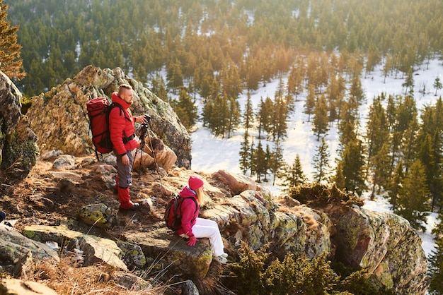 Un gruppo di turisti composto da ragazzi e ragazze che fanno foto con il treppiede in cima a una montagna