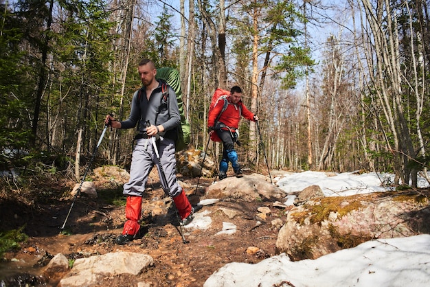 Un gruppo di turisti composto da uomini che parlano vicino al torrente nel bosco