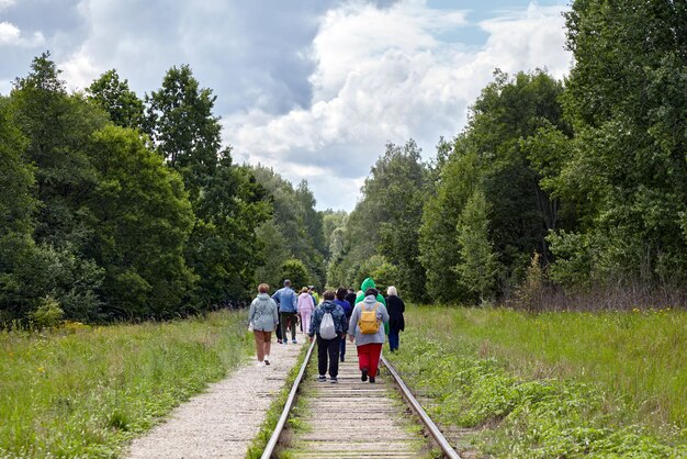 Un gruppo di turisti si muove lungo i binari ferroviari abbandonati nella foresta