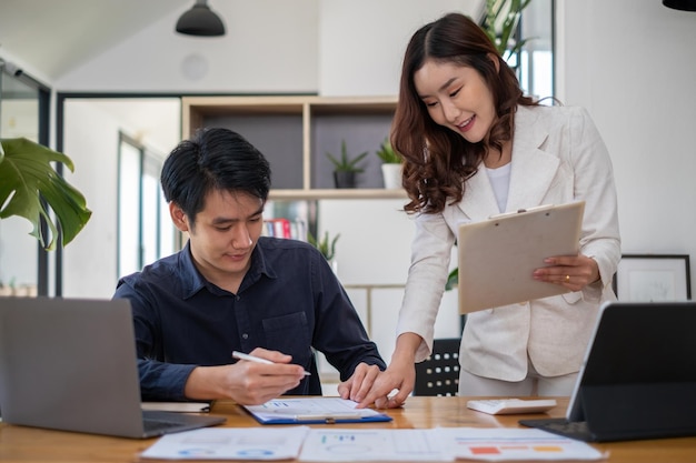 Un gruppo di uomini d'affari asiatici discutono e fanno brainstorming per analizzare e pianificare un nuovo progetto finanziario