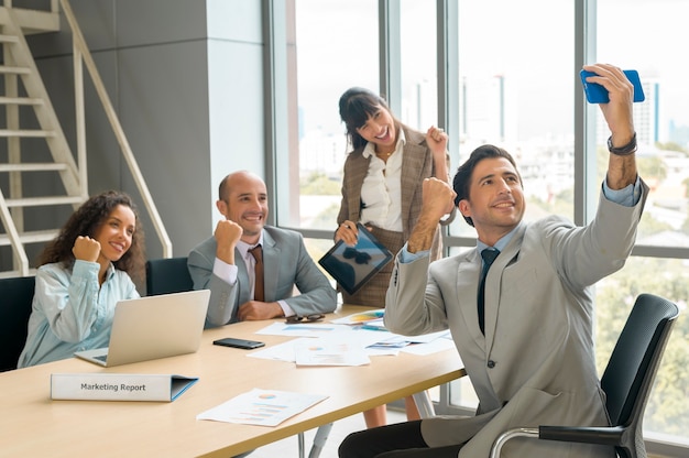 Un gruppo di uomini d'affari che si fanno selfie in ufficio