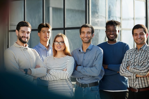 un gruppo di uomini d'affari di sei persone in piedi in ufficio guardando la telecamera in abiti casual