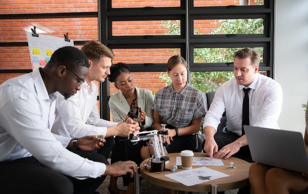 Un gruppo di uomini d'affari diversi che lavorano insieme in ufficio a brainstorming sul robot a mano