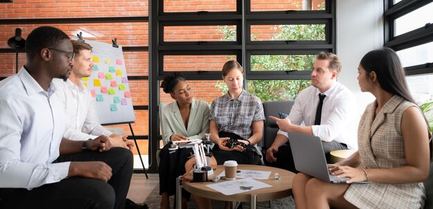 Un gruppo di uomini d'affari diversi che lavorano insieme in ufficio a brainstorming sul robot a mano