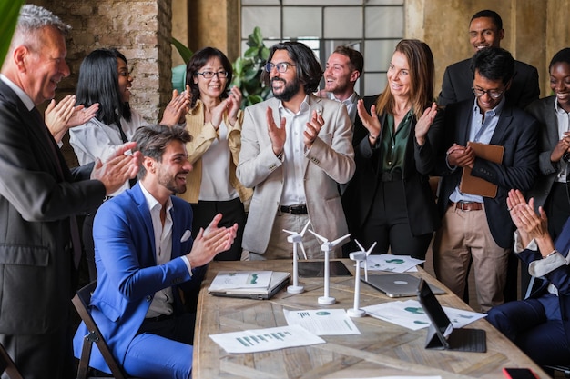 Un gruppo di uomini d'affari si è riunito in ufficio per applaudire i miglioramenti delle prestazioni dell'azienda