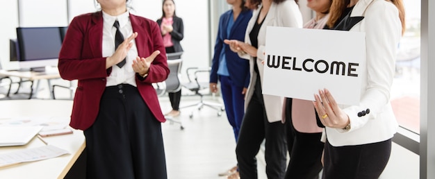 Un gruppo di uomini d'affari si unisce salutando e tenendo parole di benvenuto per un segno di felicità e piacere per l'arrivo di qualcosa o qualcuno. Buon lavoro di squadra nel concetto di ufficio.