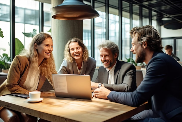 Un gruppo eterogeneo di persone che collaborano attorno a un laptop seduto a un tavolo