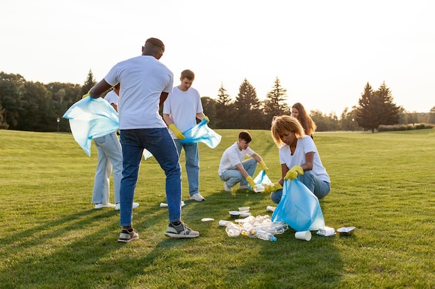 un gruppo multirazziale di volontari con sacchetti della spazzatura raccoglie spazzature e plastica