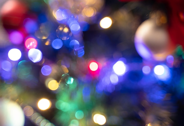 Un'immagine sfocata di un albero di Natale decorato con ghirlande di notte. Sfondo di Natale.