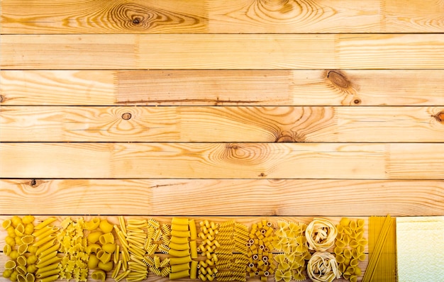 Un impasto di pasta cruda italiana allineata su un pannello di legno orizzontale Dieta mediterranea Mangiare sano