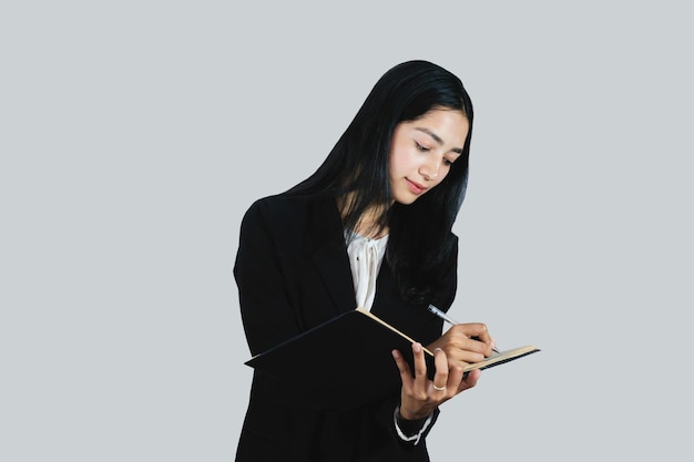 Un impiegato asiatico con un diario e un telefono cellulare che lavora in un ufficio professionalmente