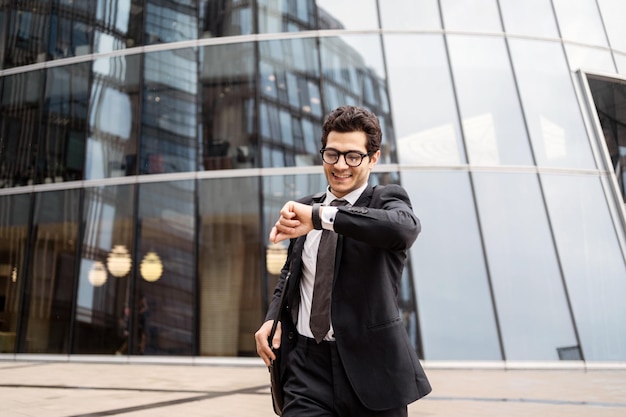 Un impiegato maschio di una società finanziaria va a lavorare in ufficio utilizza uno smartwatch