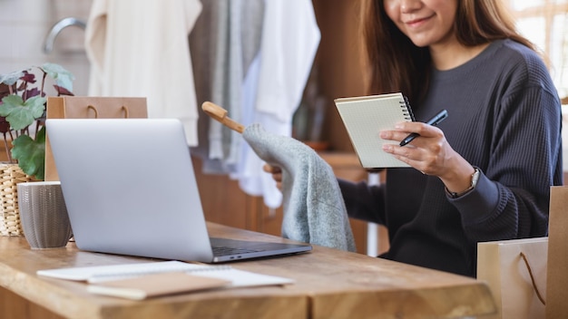 Un'imprenditrice che vende vestiti e controlla gli ordini del cliente per il concetto di shopping online