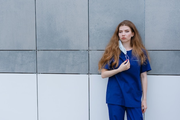 Un'infermiera stanca è in piedi fuori dalla clinica Una giovane donna durante una pausa al lavoro Pandemia di coronavirus