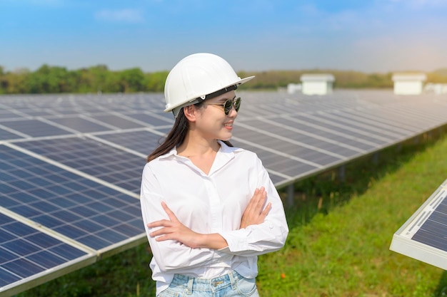 Un ingegnere donna che indossa il casco in una fattoria di celle fotovoltaiche o in un campo di pannelli solari eco