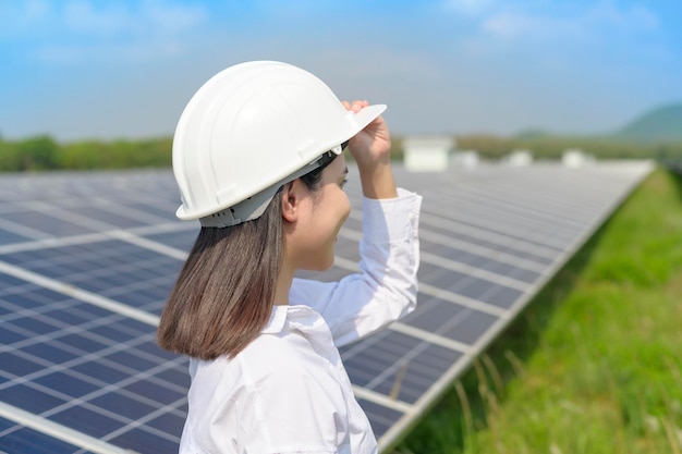 Un ingegnere donna che indossa un casco in una fattoria di celle fotovoltaiche o in pannelli solari