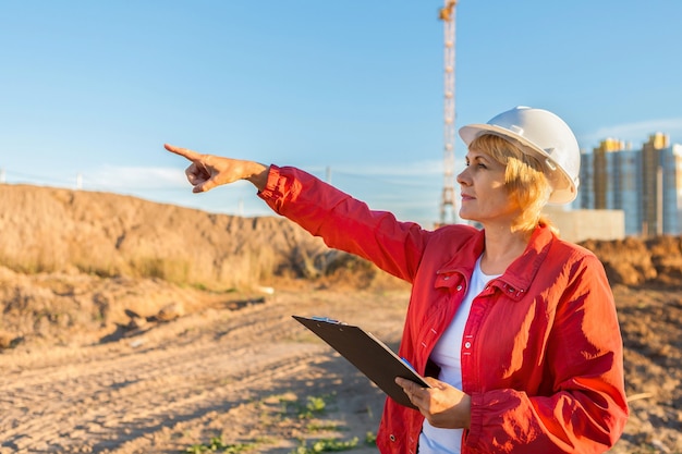 Un ingegnere edile donna è in un cantiere edile. La donna ispeziona.