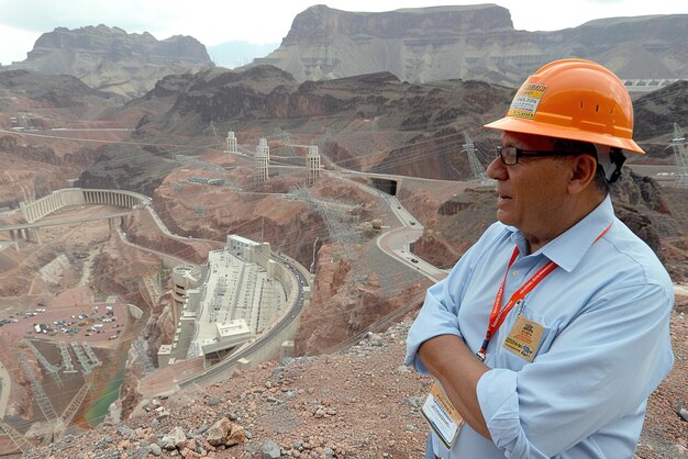 Un ingegnere esamina un'infrastruttura di stoccaggio dell'energia di una diga idroelettrica che sfrutta l'acqua per produrre c