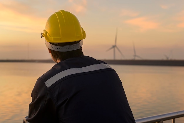 Un ingegnere maschio che indossa un casco protettivo al tramonto.