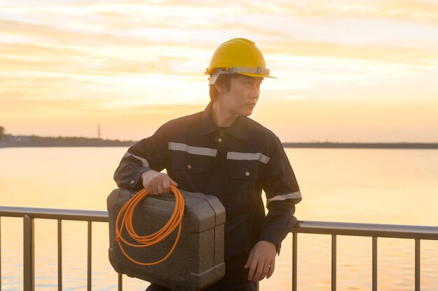 Un ingegnere maschio che indossa un casco protettivo al tramonto.