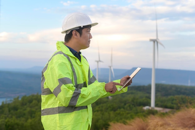 Un ingegnere uomo indossa un casco protettivo sulla testa utilizzando il tablet Analytics